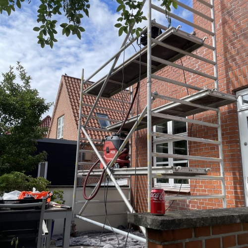 Stillads opstillet foran husmur under facaderenovering i Odense.