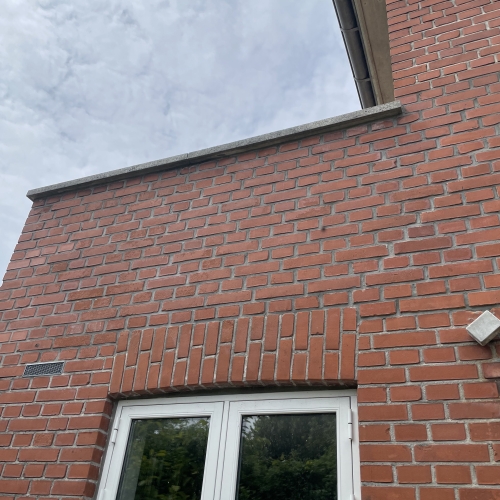 Husmur med vindue og veludført facaderenovering i Odense.