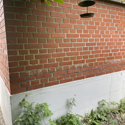 Renoveret mur med nye fuger og nymalet sokkel i Odense.