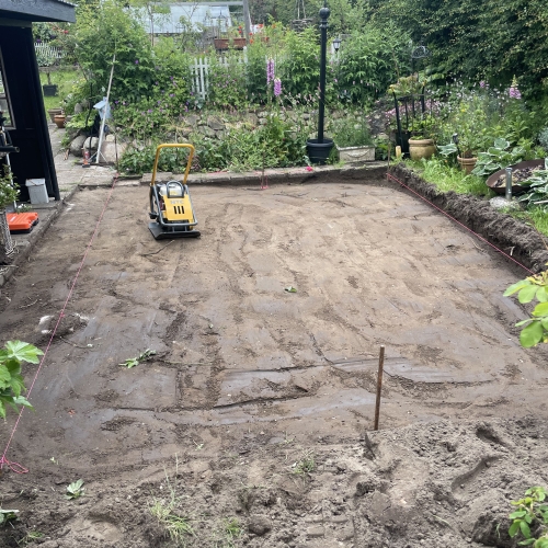 Planering af jord til fliseterrasse i en have i Ellinge, nær Odense.