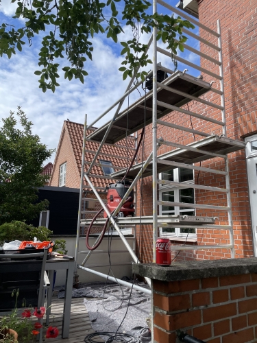 Stillads opstillet foran husmur under facaderenovering i Odense.