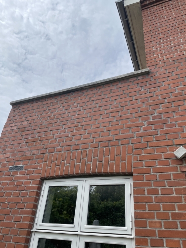 Husmur med vindue og veludført facaderenovering i Odense.