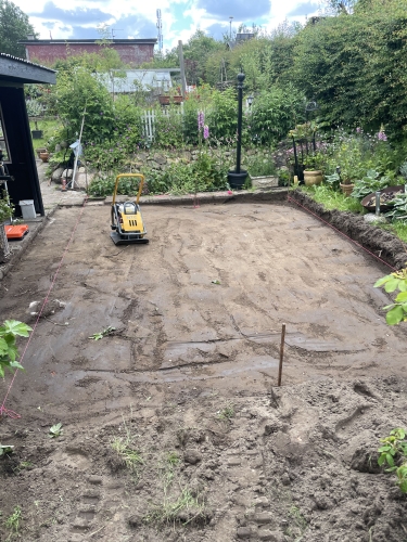 Planering af jord til fliseterrasse i en have i Ellinge, nær Odense.